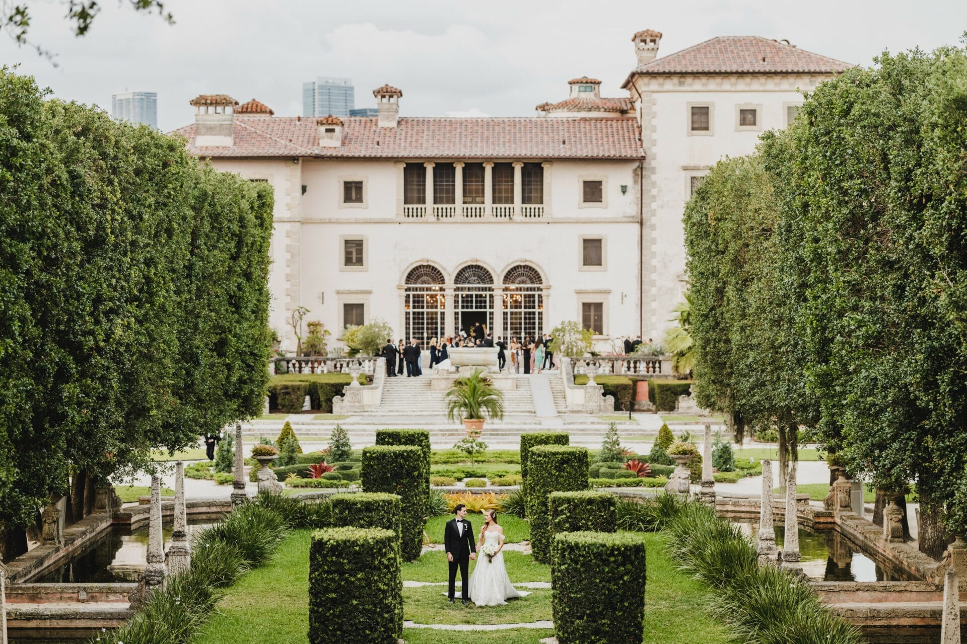 a bride and groom in front of a large white building