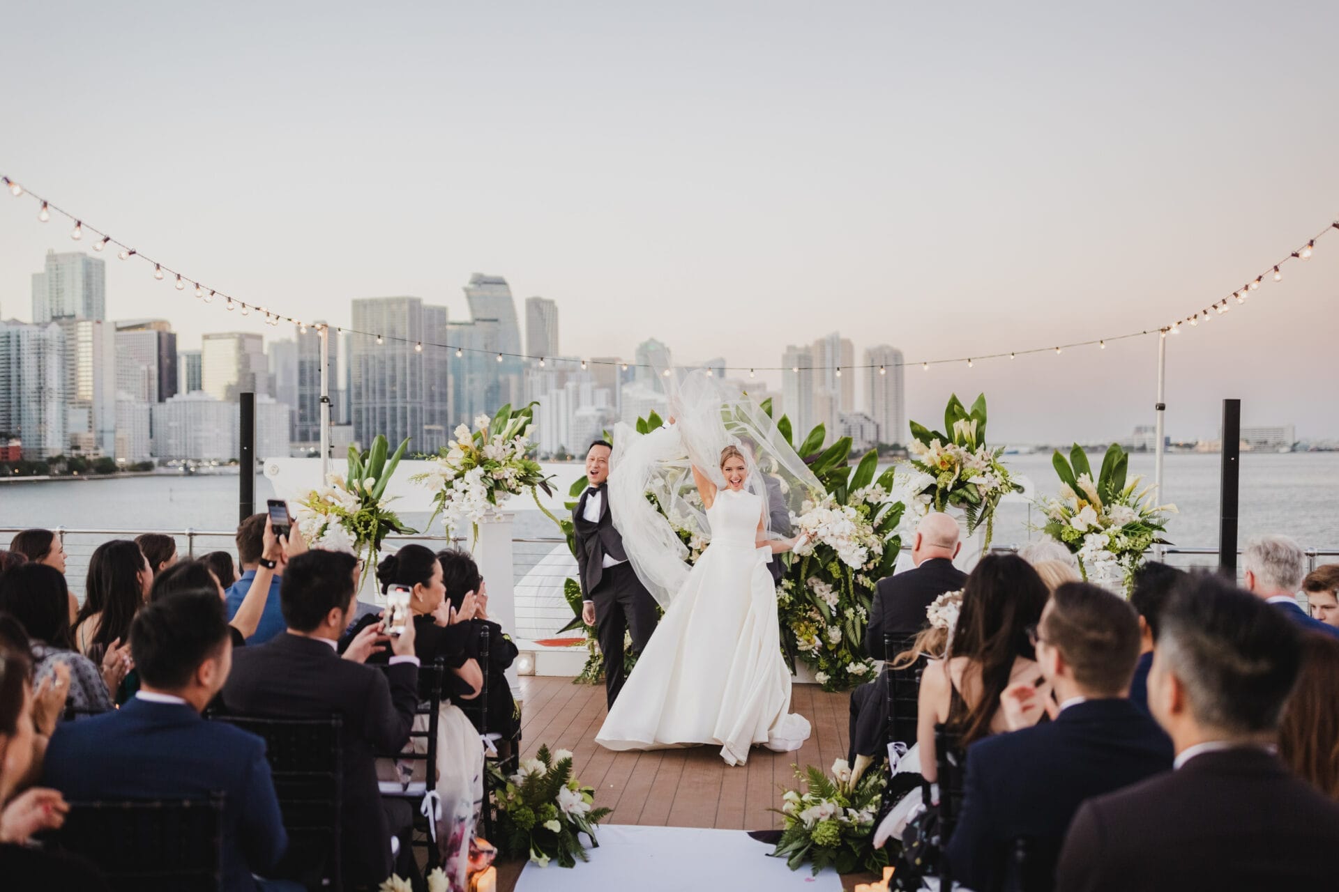 a bride walking down a deck with people watching